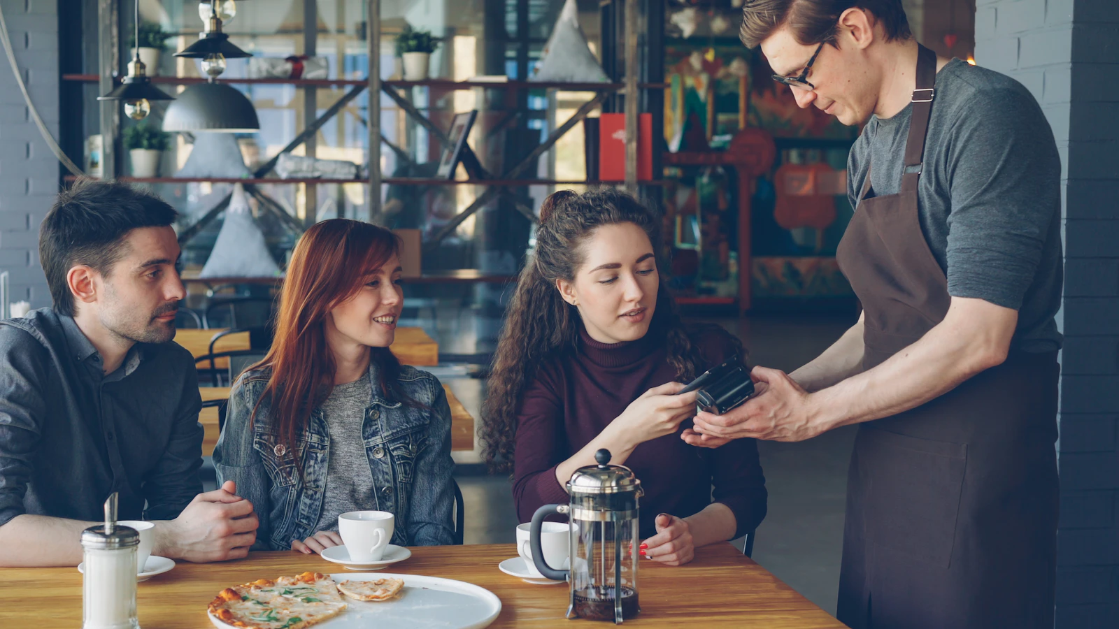 Customer making a contactless payment in a cafe